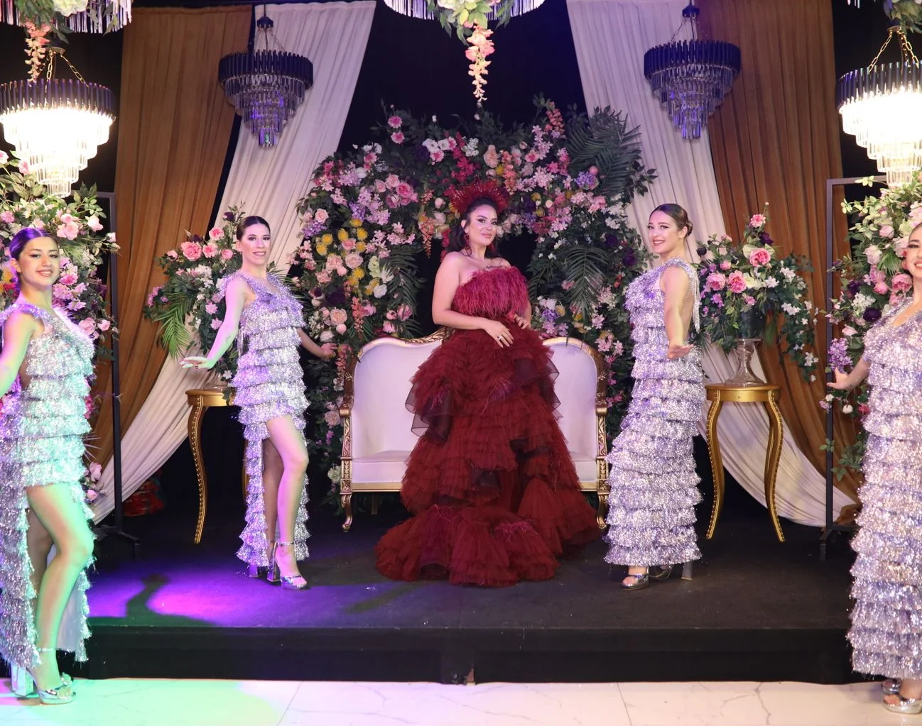 Dancers in matching sequin costumes performing at an elegant event stage show