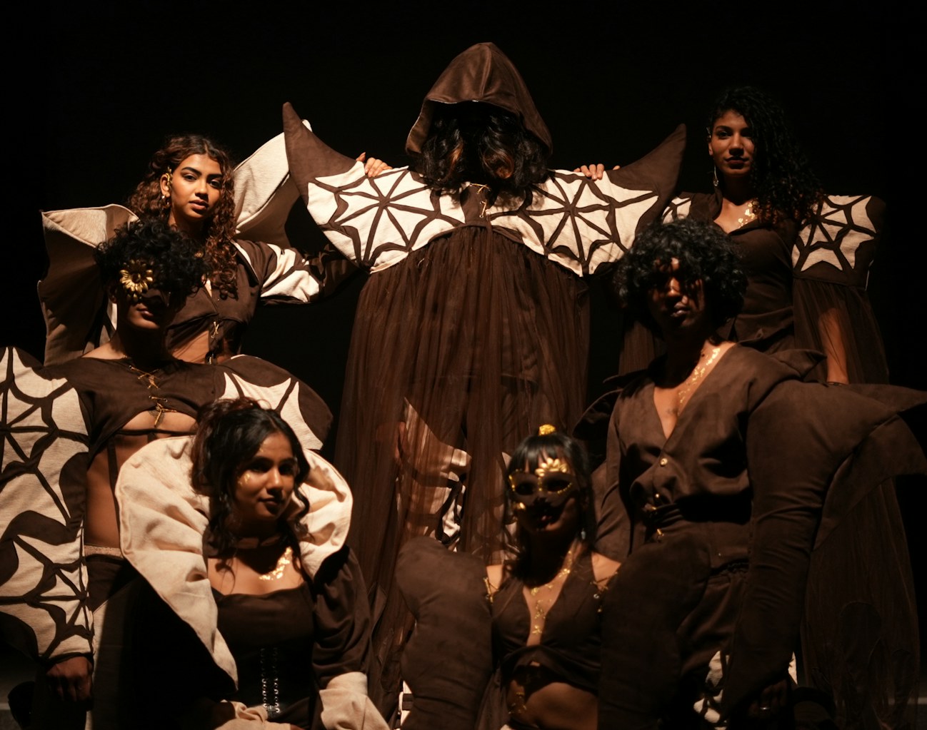 Halloween dancers in dark spider web costumes performing a live show on stage