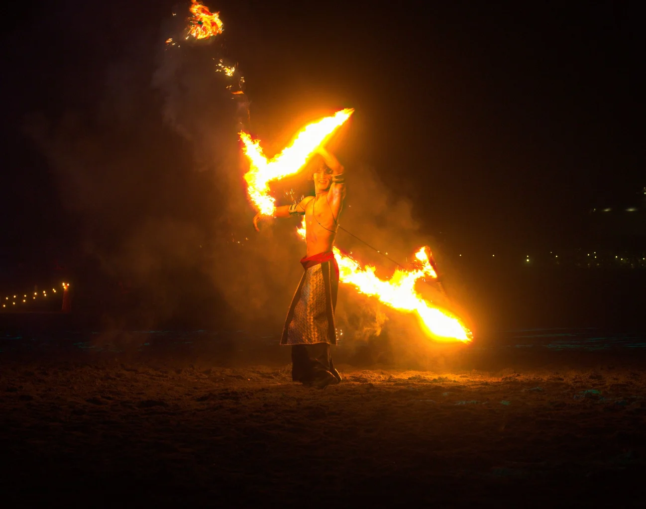 Solo fire performer spinning flames during a night show